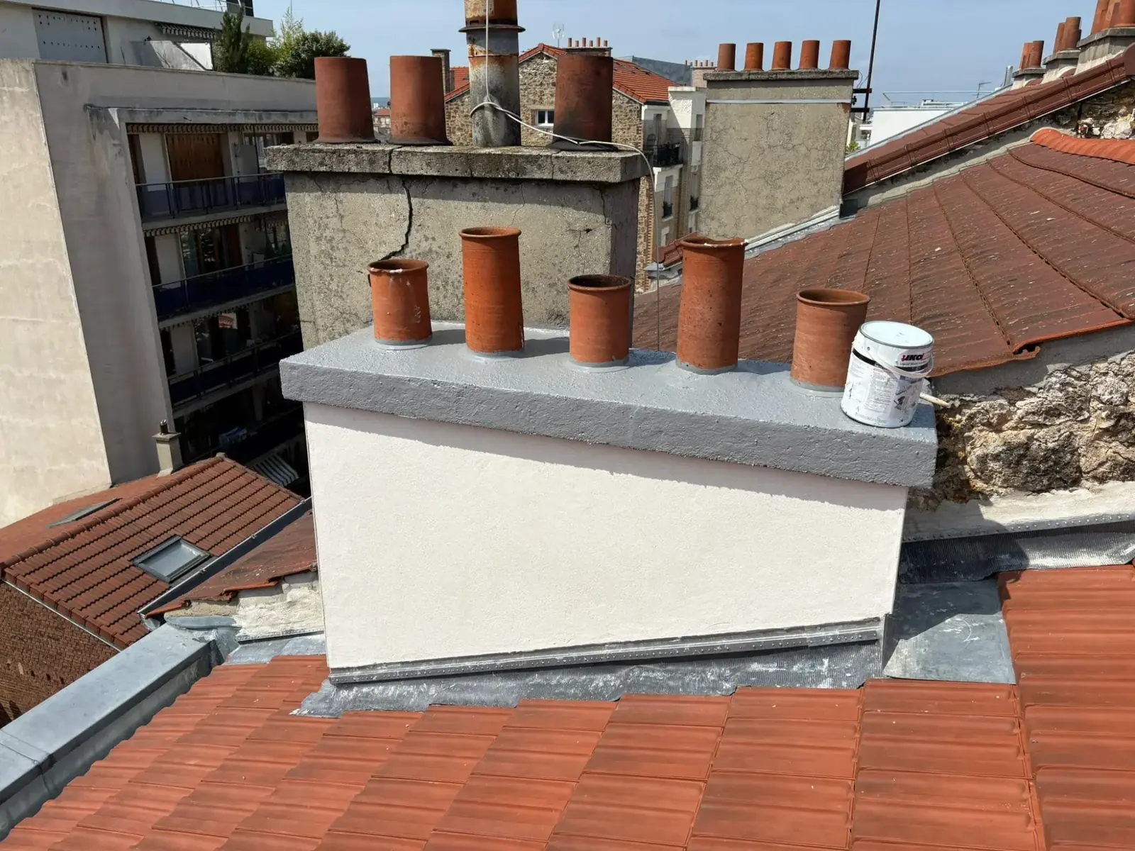 Toiture en tuiles neuve avec une bande de zinc le long du mur